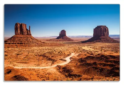 Produktbild von Wallario Frühstücksbrettchen aus Glas 20 x 30 cm mit rutschfesten Füßen, Motiv Monument Valley unter blauem Himmel