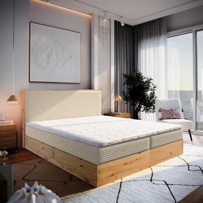 A bedroom scene with a large bed, artwork, and a window overlooking the ocean.