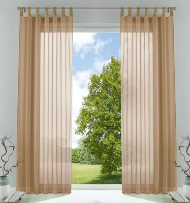 Two sheer curtains hang on a curtain rod, framing a view of a large green tree and a blue sky with clouds.