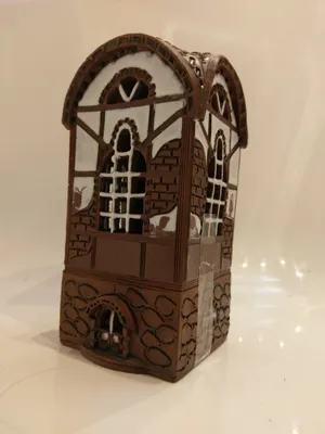 Das Keramikhaus ist in braunen, weißen und dunkelbraunen Tönen gehalten, mit einem Fachwerk-Design.