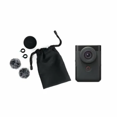 A black compact camera and its accessories are laid out on a white background.
