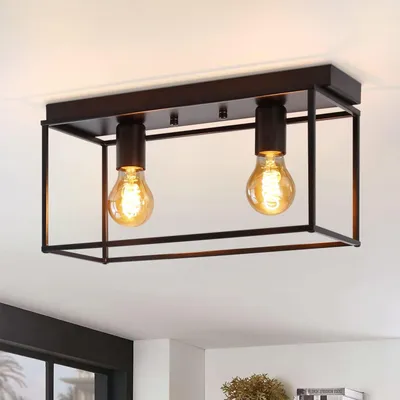 A black metal ceiling light fixture with two exposed Edison-style bulbs is mounted on a white ceiling.