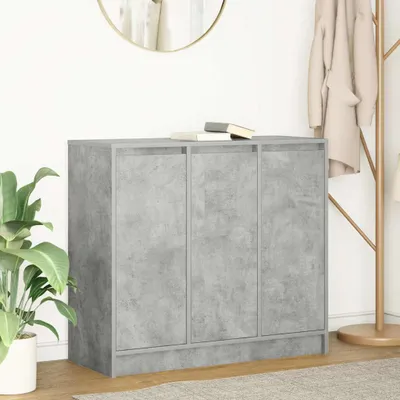 A gray cabinet with three doors, placed in a room with a plant and a coat rack.