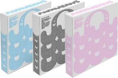 Three boxes of NewJeans albums in different colors (blue, gray, pink) are arranged diagonally.