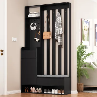 A hallway or entryway with a black and beige striped furniture piece that includes storage and hanging space.