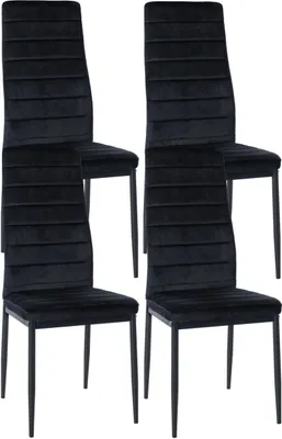 Four black velvet dining chairs arranged in a studio setting.