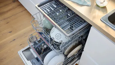 An open dishwasher filled with dishes.