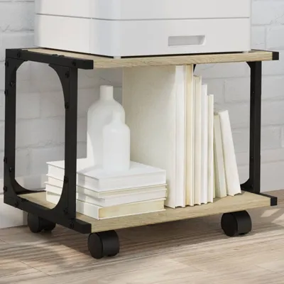 A printer stand with books and vases on it, placed on a wooden floor against a white brick wall.