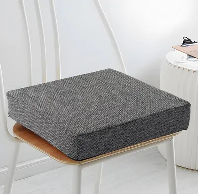 A dark gray seat cushion on a white chair.