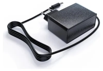 A black power adapter with a coiled black cord and a plug.