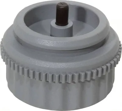 A close-up studio shot of a gray plastic valve fitting with a black central pin.