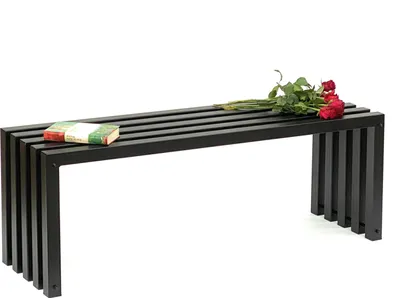 A black metal bench with a book and roses on it, set against a white background.