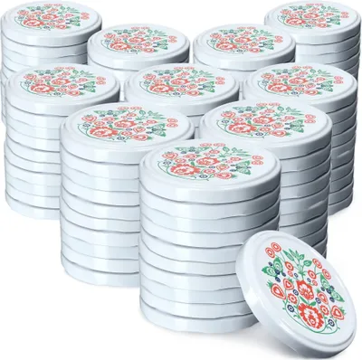 A stack of white jar lids with a floral folk art pattern.