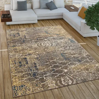 A rug is placed on a wooden floor in front of a sectional sofa.