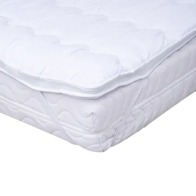 A white mattress topper is shown on top of a mattress.