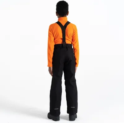 A child wearing ski pants and a turtleneck, viewed from the back.