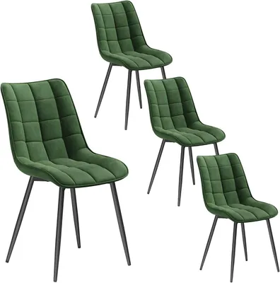 A set of four dark green velvet dining chairs with black metal legs.