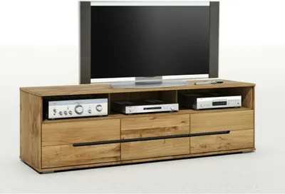 A TV lowboard made of oiled solid wood with a television and electronic devices on it.