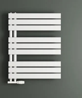 A white radiator is mounted on a gray wall.