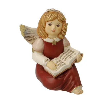 A ceramic angel figurine holding an open book with musical notes.