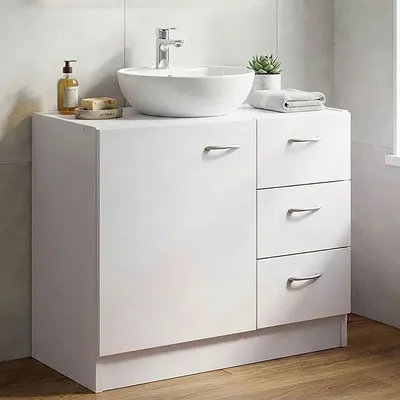 A white bathroom vanity with a sink and faucet.