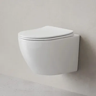A white wall-mounted toilet with a closed lid against a light gray wall.