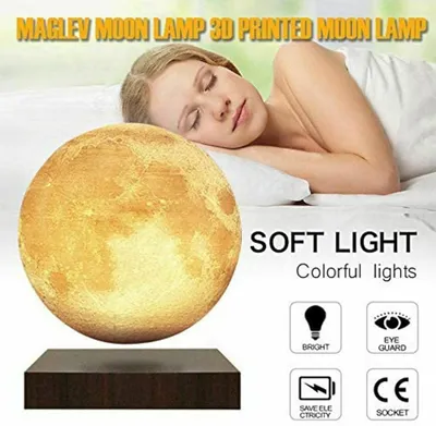 A woman sleeping in bed next to a levitating moon lamp.
