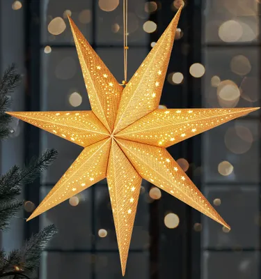 A 3D star-shaped lantern hangs in front of a window with bokeh lights.