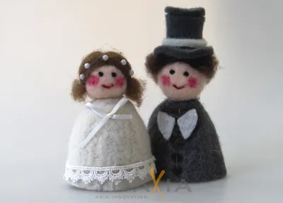 Two felt dolls, a bride and groom, are displayed against a white background.
