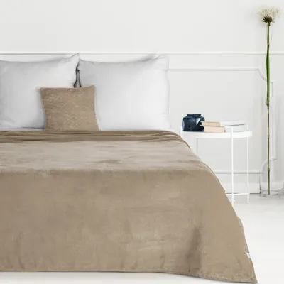 A neatly made bed with two pillows and a beige blanket.