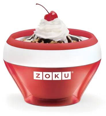 A Zoku ice cream maker in red and white, filled with ice cream, whipped cream, chocolate sauce, nuts, and a cherry on top.