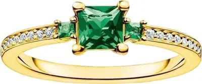 A close-up studio shot of a gold ring with a large square-cut emerald and smaller emeralds and diamonds.