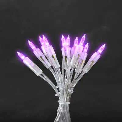A bunch of purple LED mini lights tied together against a black background.