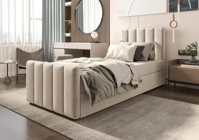 A bedroom scene featuring a boxspring bed, dresser, chair, and curtains.