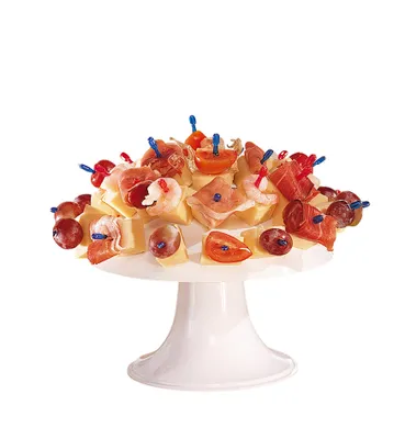 A white cake stand filled with various appetizers on toothpicks.