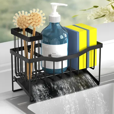 A black metal dish rack with a blue soap dispenser, two yellow sponges, and two brushes, placed over a sink with water draining.