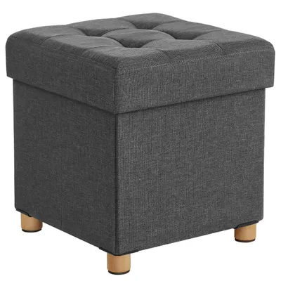 A dark gray upholstered storage ottoman with wooden legs is shown against a white background.
