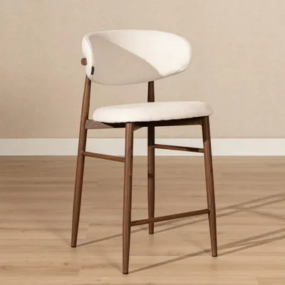 A bar stool is shown in a room with a light beige textured wall and a wooden floor.