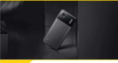 A dark, minimalist scene with a black smartphone leaning against a dark surface.