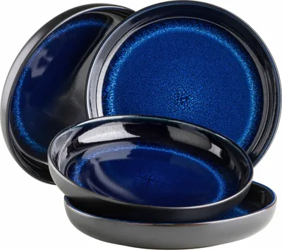 A set of deep blue ceramic bowls with black rims, stacked and angled against a white background.