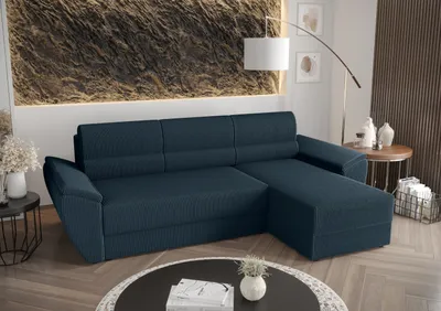 A dark blue sectional sofa with a chaise lounge is shown in a modern living room setting. The sofa is positioned in the center of the image, with decorative elements and furniture in the background.