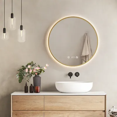 A modern bathroom vanity with a round LED mirror, a vessel sink, and decorative items.