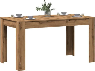 A wooden dining table set with place settings and a vase of flowers.