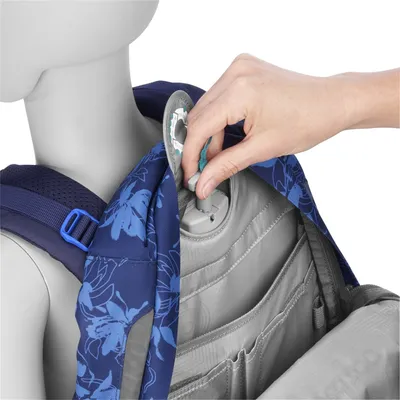 A hand is shown inserting a component into a backpack.