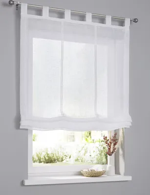 A white sheer curtain hanging on a window rod, with a window view of greenery outside.