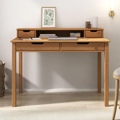 A wooden desk with drawers and an upper shelf, set against a light gray wall.