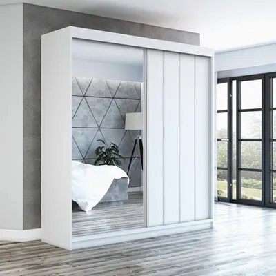 A modern bedroom with a large sliding door wardrobe with mirrored doors.