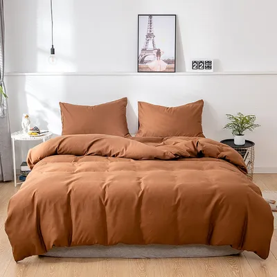 A neatly made bed with brown bedding in a room.