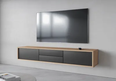 A modern, wall-mounted TV stand with drawers and a television mounted above it.