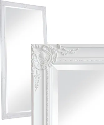Two white baroque-style mirrors are shown against a white background. One mirror is in the foreground, showing a close-up of its ornate corner. The second mirror is in the background, appearing larger and taller.